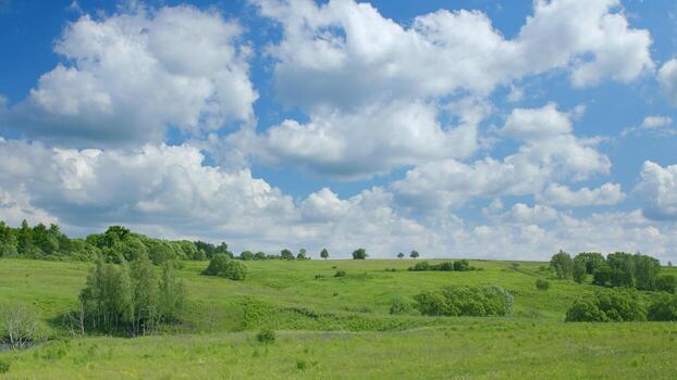 Scenic landscape with rolling green hills, trees and bright sky representing active outdoor leisure